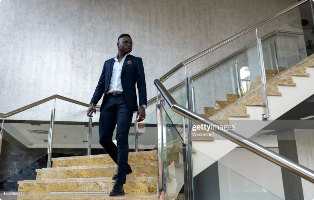 Confident male entrepreneur looking away while walking downstairs.