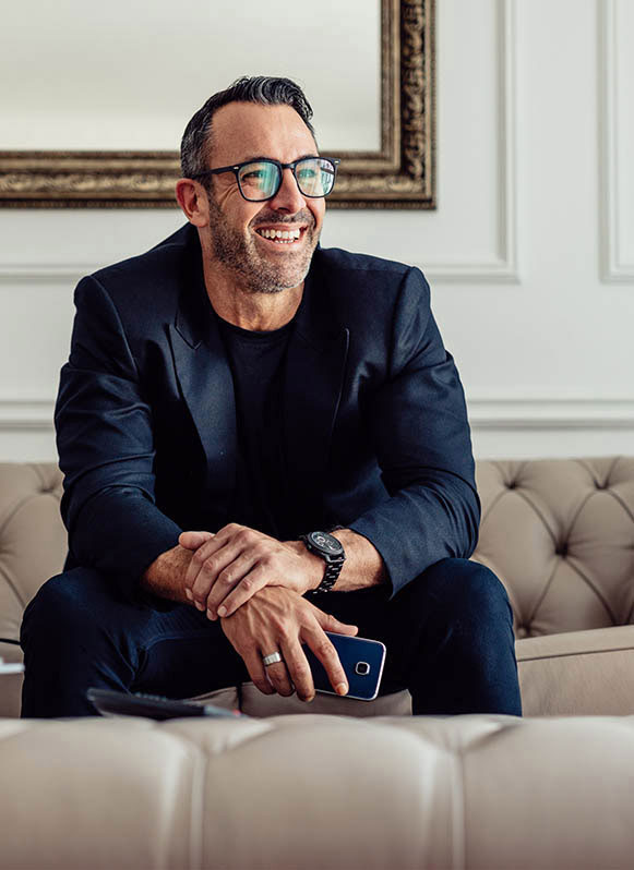 Happy mature businessman sitting on sofa.
