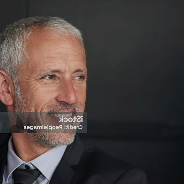 Cropped shot of a handsome mature businessman standing in the office while looking outside a window.