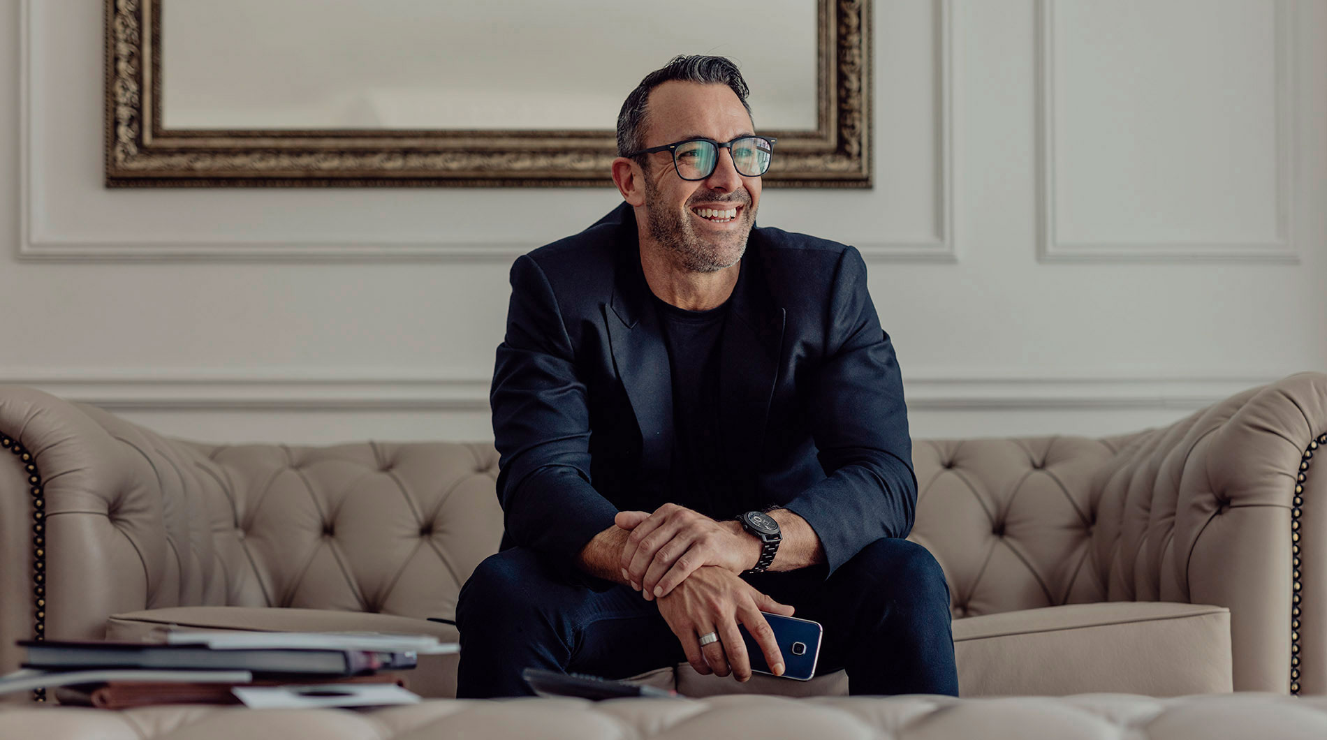 Happy mature businessman sitting on sofa.