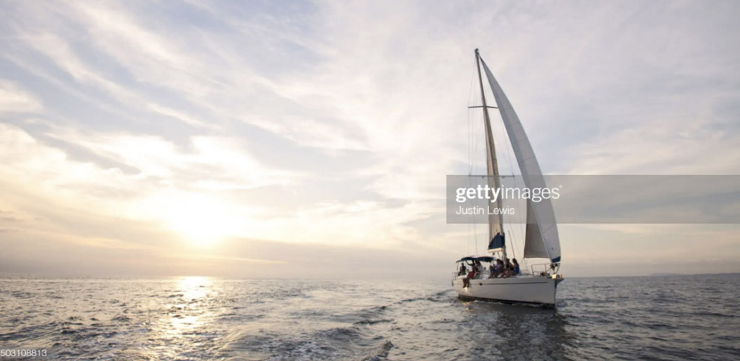Sailboat cruise during gorgeous sunset at sea.