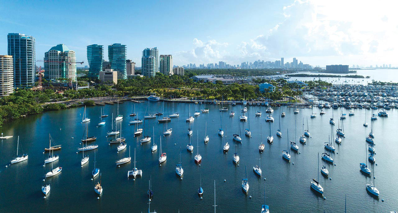 Panoramic view of Coconut Grove bay with a large group of boats anchored on the shore. Aerial view.
